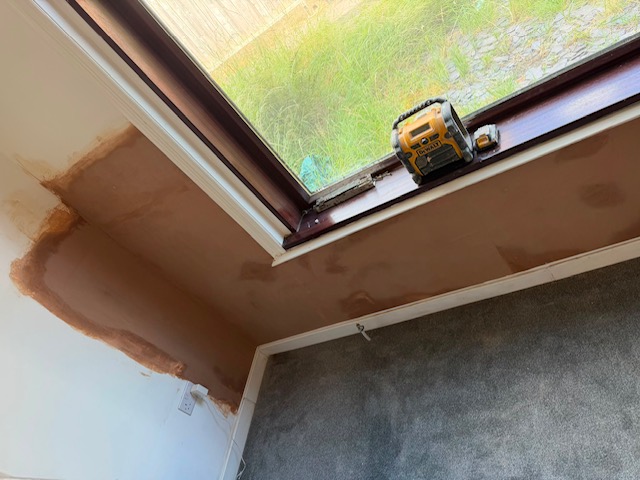 A render coat applied around a window reveal after damp proofing