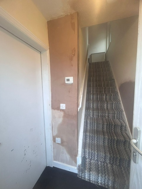 A landing and staircase replastered after damp proofing work