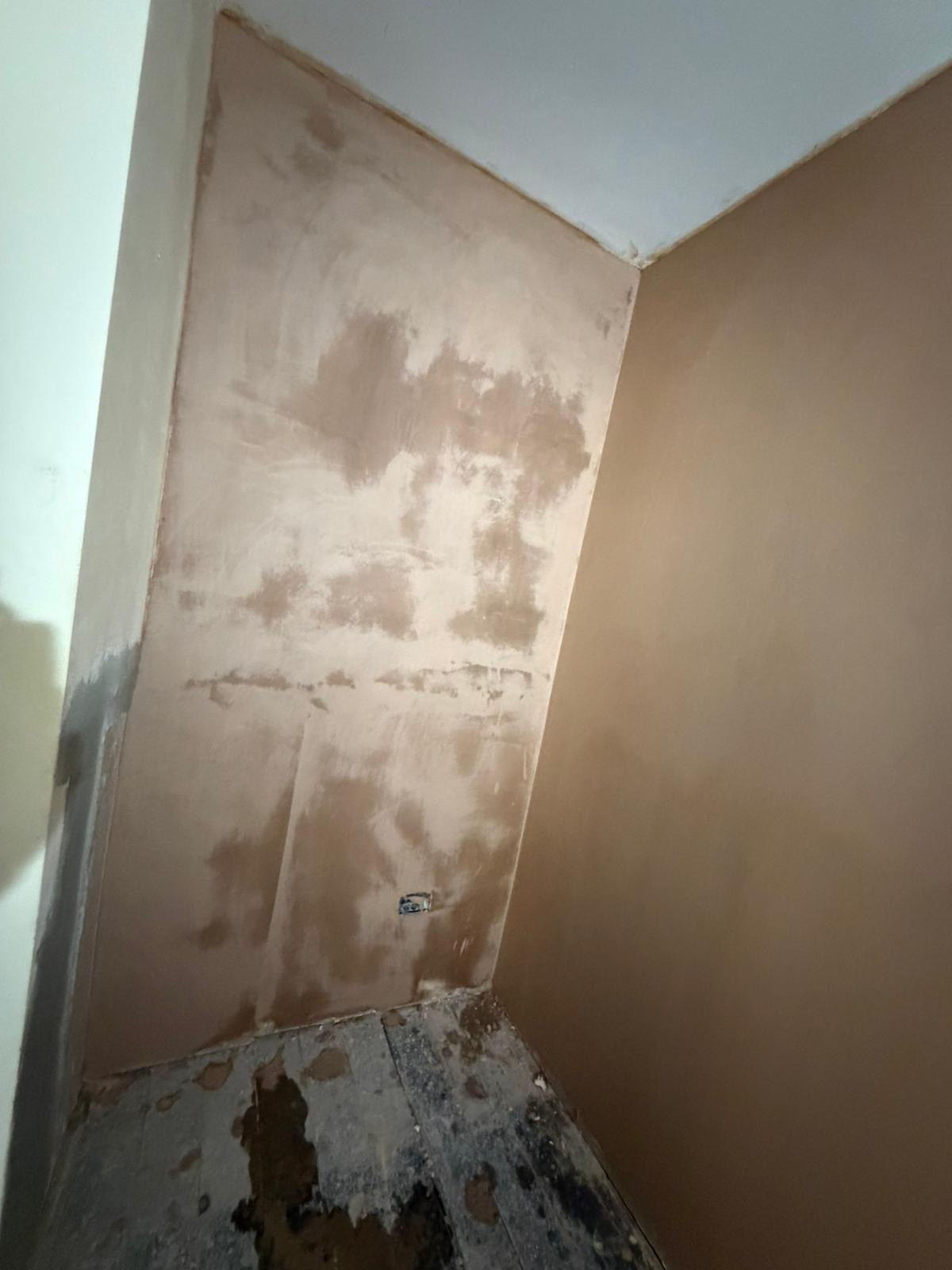 Plaster hacked off a corner wall back to bare masonry during damp proofing