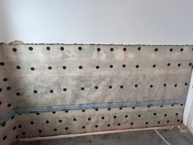 A long wall fitted with tanking membrane and plugs after rising damp treatment