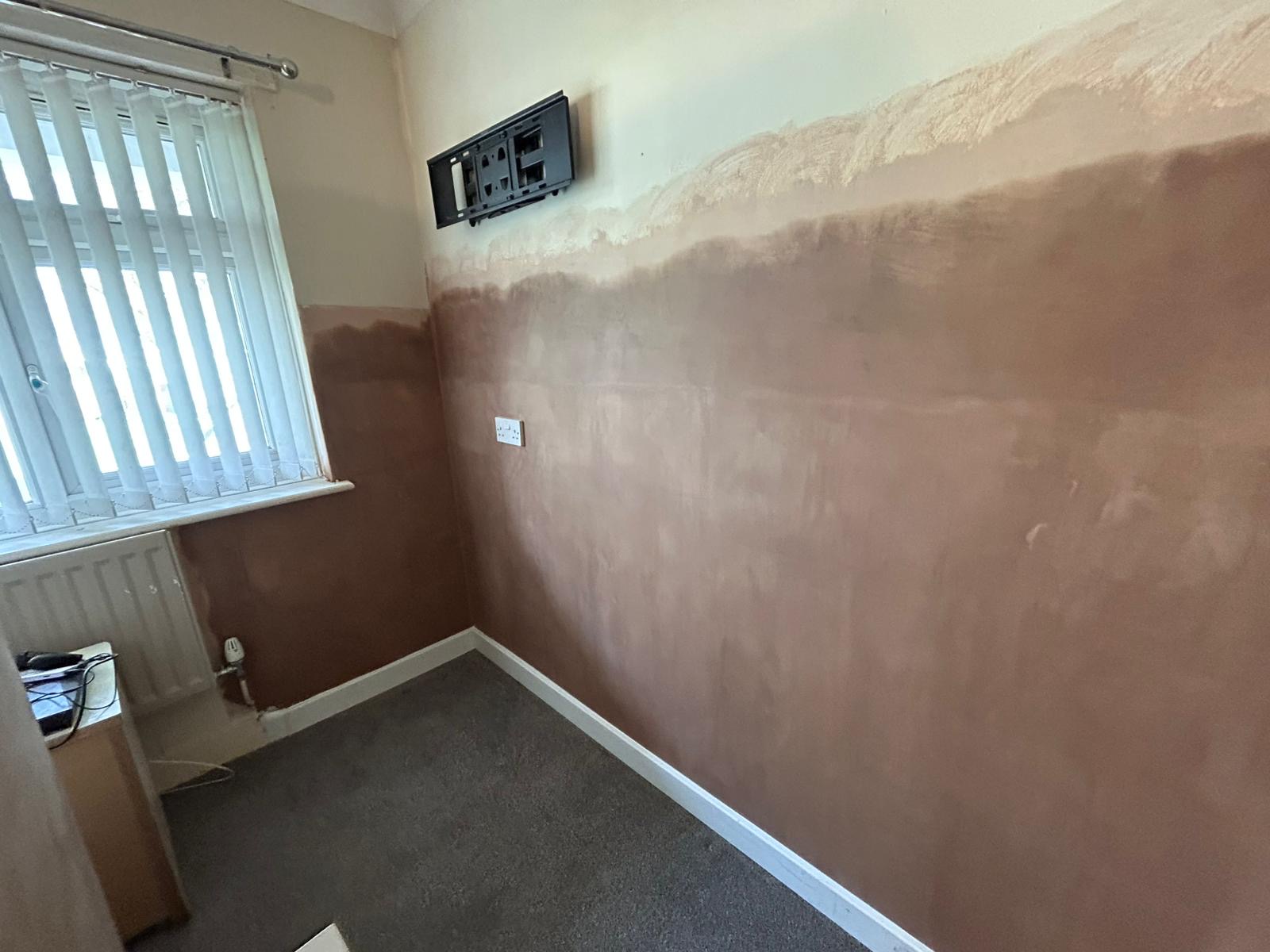 A wall mid replastering with the render coat applied to the lower half